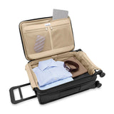 Briggs & Riley Baseline Essential Carry-On Spinner luggage in blue with four spinner wheels and durable hard shell exterior.