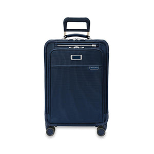 Briggs & Riley Baseline Essential carry-on spinner luggage in blue with four wheels and retractable handle for easy travel.
