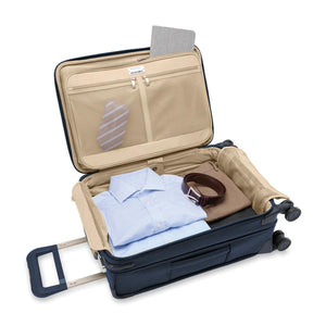 Briggs & Riley Baseline Essential Carry-On Spinner luggage in blue with four spinner wheels and a telescoping handle.