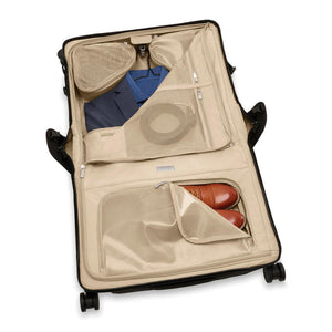 Briggs & Riley Baseline wide carry-on wheeled garment spinner suitcase with navy blue exterior and four spinner wheels.