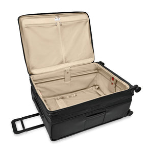 Briggs & Riley Baseline extra large expandable checked luggage spinner in blue with four wheels and multiple compartments.
