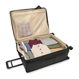 Briggs & Riley Baseline extra large expandable checked luggage spinner with blue hard shell and four wheels.