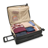 Briggs & Riley Baseline large expandable checked luggage spinner in blue with four wheels and a sturdy handle.