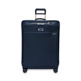 Briggs & Riley Baseline large expandable checked luggage spinner with blue hard shell exterior and four wheels for easy rolling.
