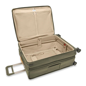 Briggs & Riley Baseline large expandable checked luggage spinner with blue exterior, four wheels, and built-in TSA lock.
