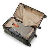 Briggs & Riley Torq extra large checked luggage trunk with spinner wheels and hard shell, black travel suitcase on airport floor.
