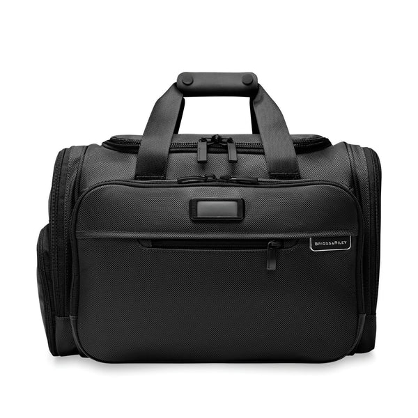 Briggs & Riley Baseline underseat duffel bag with black fabric, compact design, and sturdy handles for travel convenience.