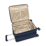 Briggs & Riley Baseline Global Carry-On Spinner suitcase in blue with four wheels and telescopic handle, ready for travel.