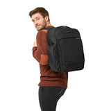 Briggs & Riley Baseline Traveler Backpack with multiple compartments and padded shoulder straps, black travel backpack on a plain background.