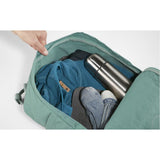 Fjallraven Kanken backpack in frosty green with top carrying handle and adjustable shoulder straps, front logo patch, and zip compartments.