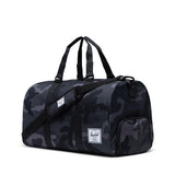 Herschel Novel Duffle bag in black with leather accents and adjustable shoulder strap, shown on a white background.