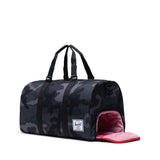 Herschel Novel Duffle bag in black fabric with leather accents, featuring handles and a shoulder strap for travel and daily use.