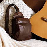 Jack Georges Voyager sling bag in brown, shown in a lifestyle setting with adjustable strap and multiple compartments.