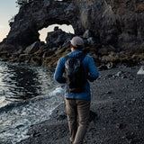Matador Freefly16 packable backpack in black, showing its compact design and adjustable straps for outdoor travel.