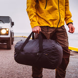 Matador Transit30 duffle bag in black with adjustable shoulder strap and multiple zippered compartments on a white background.