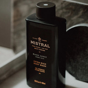 Men's Body Wash by Mistral featuring black amber scent, clear bottle with black cap and sleek design.