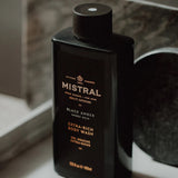 Men's Body Wash by Mistral featuring black amber scent, clear bottle with black cap and sleek design.