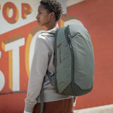 Peak Design Travel Backpack 30L in sage green, showing the sleek exterior with adjustable straps and front zip compartments.