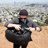 Lightbox image of Peak Design Travel Backpack 45L showing its sleek black exterior with multiple compartments and padded shoulder straps.