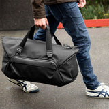 Black Peak Design Travel Duffel 35L bag with durable fabric, sturdy handles, and a spacious main compartment for travel gear.