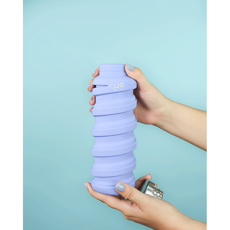 Que Bottle accessory, collapsible and portable, designed by Que, shown in a compact, folded state for easy storage and convenience