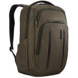 Thule Crossover 2 20L backpack shown with multiple compartments, padded straps, and durable fabric in a natural outdoor setting.