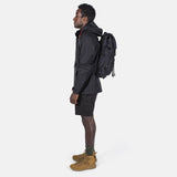 Topo Designs Rover Pack Tech backpack showing durable black fabric, adjustable straps, and multiple compartments on a plain background.