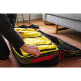 Topo Designs Global Travel Bag roller carry-on luggage with adjustable handle and multiple compartments in durable fabric.