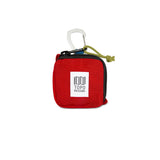 Red Topo Designs square bag used for packing organization, featuring a compact, square shape with sturdy material and zipper closure.