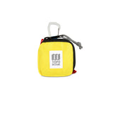 Yellow Topo Designs Square Bag used for packing organization, featuring a compact, square shape and durable fabric for travel and storage.