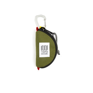 Olive green Topo Designs Taco Bag used for packing organization, showing compact, cylindrical storage with top zipper and adjustable strap.