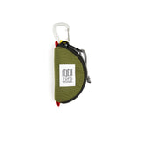 Olive green Topo Designs Taco Bag used for packing organization, showing compact, cylindrical storage with top zipper and adjustable strap.