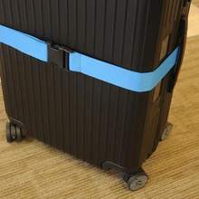 Blue adjustable luggage strap from Voltage Valet, a durable travel essential for securing and identifying your luggage.